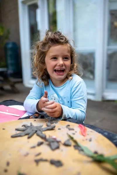 a smiling child with clay